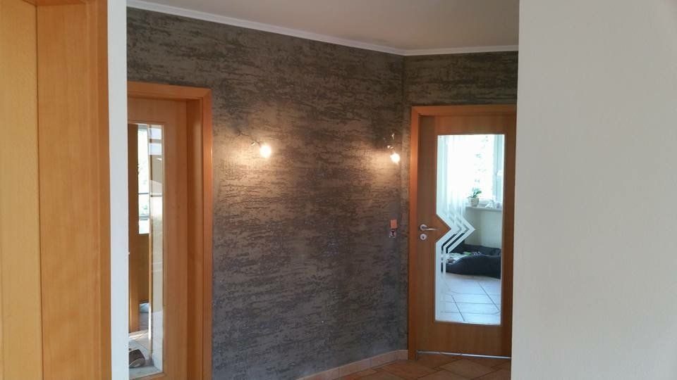 Flur mit dunkler Wand in Schieferoptik zwischen zwei Holztüren