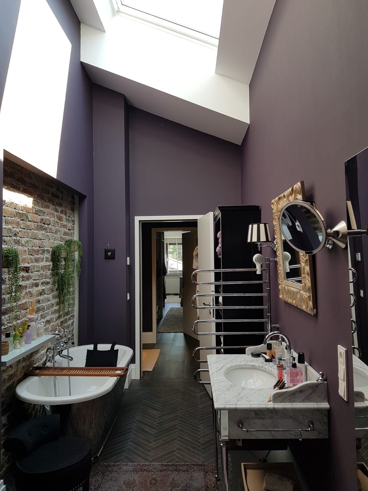 Treppenhaus mit aubergine gestrichener Wand und Natursteinsockel