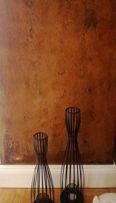 Wand in Rost-Patina mit zwei dunklen Vasen